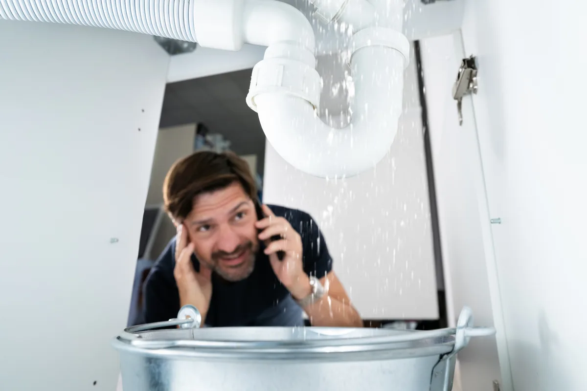 Burst pipe flooding under a sink